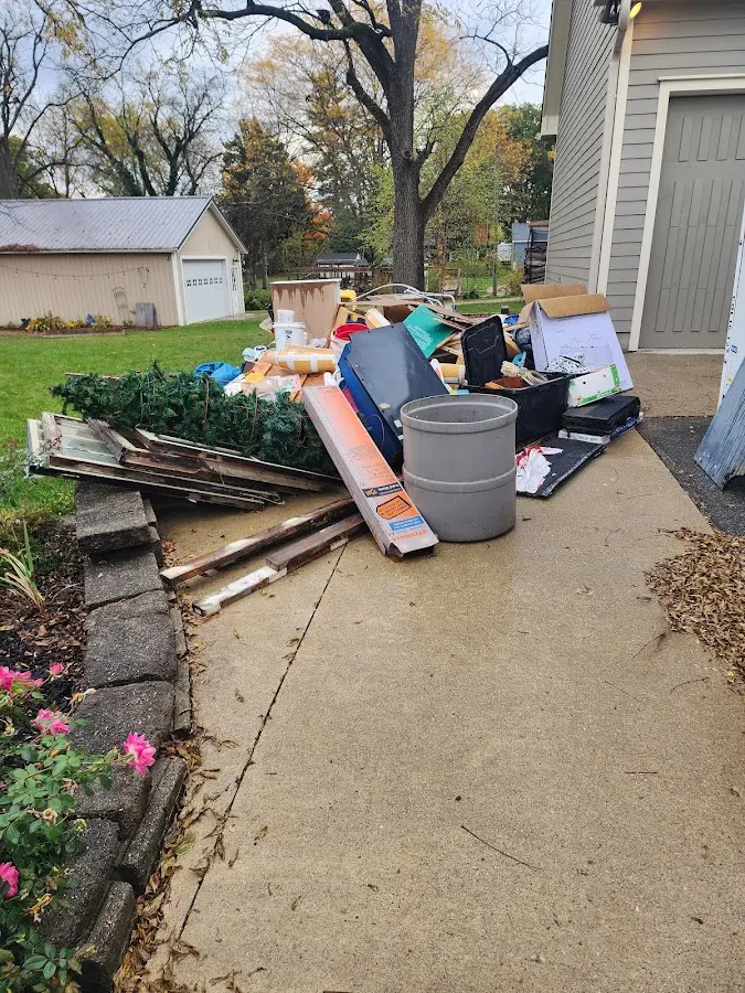 Dumpster being loaded with debris for 10 Yard Dumpster Rental in Manistee